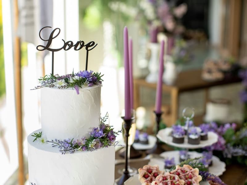 紫の花々で飾られたウェディングケーキイメージ。結婚式二次会・1.5次会に、新郎新婦と大切なゲストの特別なひとときを華やかに彩ります。