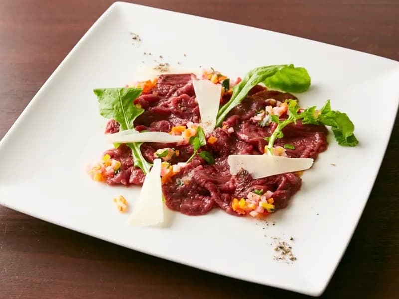 上質な馬肉が入った時に登場する日替わりメニュー「馬肉のカルパッチョ」。柔らかな赤身肉に、イタリア伝統の野菜ソース、カンパニョーラソースを添えました。肉の濃厚な旨みとコクに、野菜たっぷりのさっぱりソースが調和します。