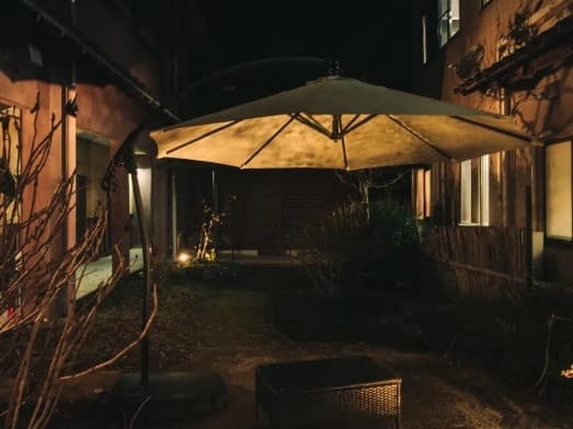 【中庭】
夜の灯りに包まれた、温泉旅館の静かな中庭。