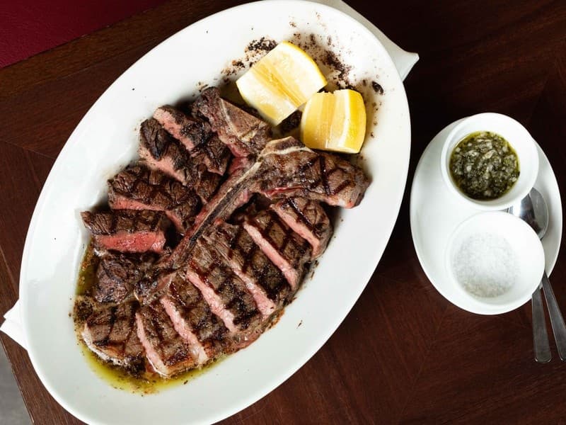 お店のスペシャリテ（看板料理）の一つが、イタリア・フィレンツェの名物である「ビステッカ アッラ フィオレンティーナ（Tボーンステーキ）」です。骨を挟んで「ヒレ」と「サーロイン」の2つの部位を一度に味わえる贅沢な一皿です。