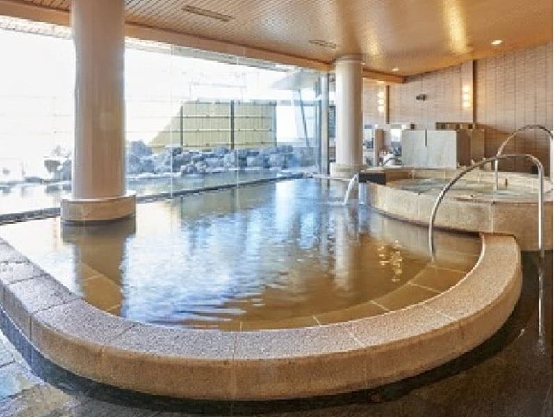 【14F 大浴場　天-TEN-】
ホテル最上階に位置する天然温泉が湧き出る大浴場。野趣あふれる露天風呂や、源泉掛け流しのかめ湯やサウナ、そしてロビーにはマッサージチェアも併設され、温泉旅館さながらのくつろぎをご体感いただけます。