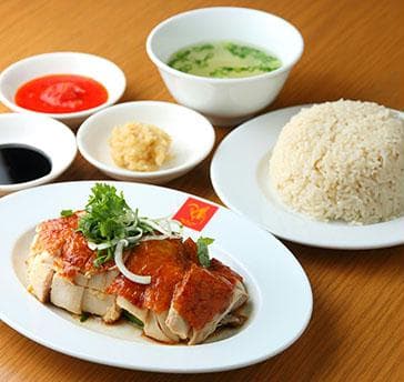 蒸し鶏とチキンスープで炊いたご飯を、ダークソイソースとチリソース、おろし生姜を合わせたソースで味わうのが、シンガポールチキンライス。伝統的なシンガポール御味を楽しんで