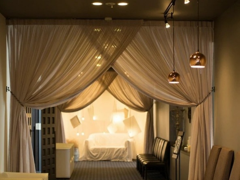 柔らかなドレープカーテンと温かみのある照明が、ロマンティックな雰囲気を演出する空間。新郎新婦とゲストが距離近く過ごせる、アットホームなパーティーにぴったりです。