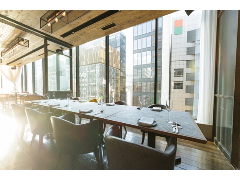 大きな窓から自然光が差し込む、開放感あふれる半個室風のスペース。少人数でのご会食にも最適です。個室利用のミニマムチャージ（税込） ランチ33,000円 ディナー88,000円から。