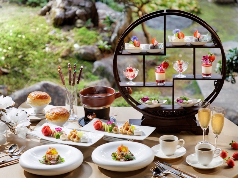 庭園を眺めながら楽しむ、華やかなアフタヌーンティ。色とりどりのスイーツと軽食が、優雅なひとときを演出します。