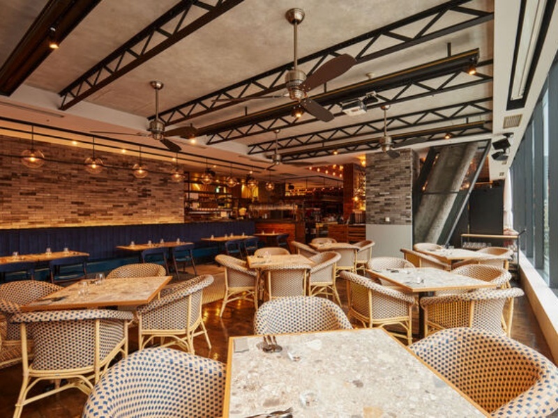 ラタンチェアとレンガ壁が調和した明るく開放的な店内。居心地よくお食事をお楽しみいただける空間です。